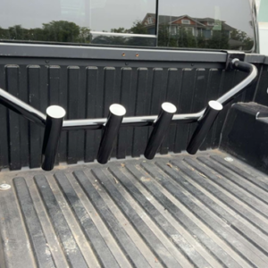 No-drill truck bed fishing rod holder with four angled rod tubes installed in a pickup truck bed, designed to work with a bed cover.